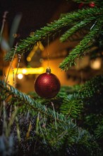 Red Christmas tree ball on fir tree at night