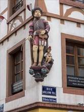 Corner of the half-timbered house with the carved figures of William Tell