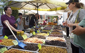 Turkish woman selling olives at the weekly market market of Cunda