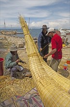 Men tying a traditional thatched boat with tortora reeds