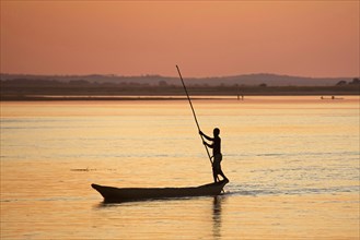 Silhouette of Malagasy fisherman punting pirogue