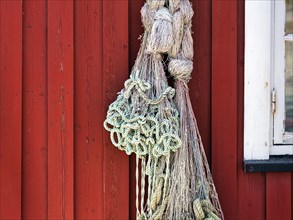 Net hanging from red wooden fishing hut