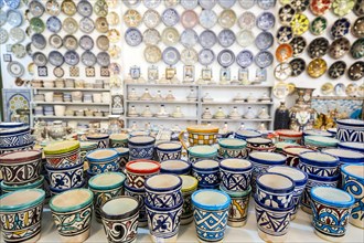 Shelves full of handmade ceramic products in pottery factory in Fez