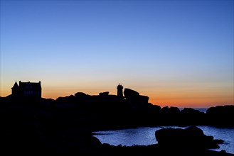 Pors Kamor lighthouse and house built by Gustave Eiffel silhouetted against sunset at Ploumanac'h