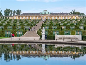 The water reflection of the Great Fountain and behind it Sanssouci Palace with the staircase and Sanssouci Park