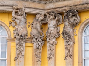 Detail of the yellow building with human sculptures at Sanssouci Palace