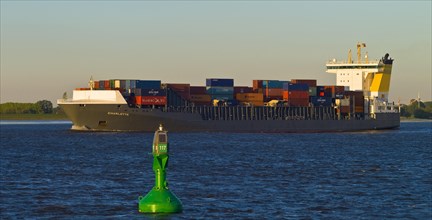 Container ship on the Elbe near Luehe in the evening light
