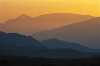 Silhouettes of successive hills and mountains at sunset in the Scottish Highlands