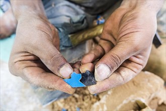 Craftsman showing hand made tiny ceramic tiles that perfectly fit each other in pottery factory in Fez