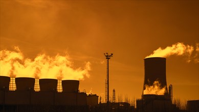 Industrial estate at sunset showing cooling tower and chimneys at the BASF chemical production site in the port of Antwerp
