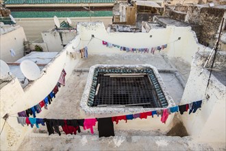 Drying clothes on the rooftop terrace of a traditional house in Arabic medina of Fes