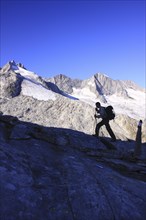 Silhouette of mountain walker with backpack and walking poles in the mountains of the Wildgerlostal