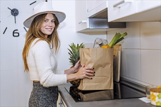 Portrait of a woman coming home from the supermarket with the purchase of vegetables and fruits
