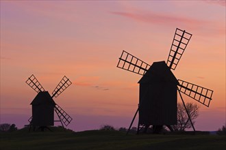 Two traditional windmills at Resmo silhouetted against sunset on the island Oeland