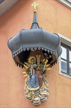 Sacred sculpture of Mary and the Child Jesus under a canopy on a residential house