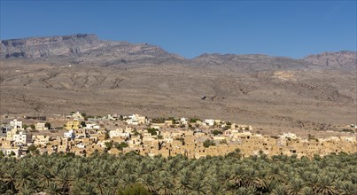 Abandoned ghost town of Al Hamra with Hajar Mountains in the background