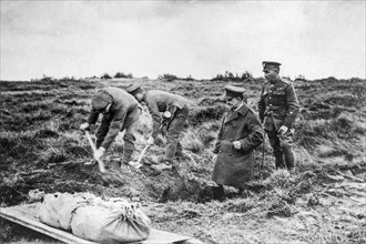 British soldiers in 1919 excavating dead WWI soldiers fallen on the Western Front battlefield during the First World War One