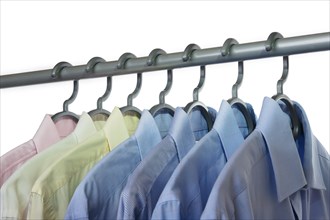 Business shirts hanging on a clothing rail and cut out on a white background