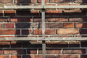 Wooden grid in front of brick wall
