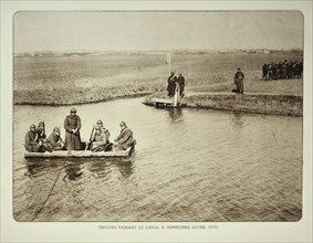 Soldiers crossing canal by boat at Adinkerke in Flanders during the First World War