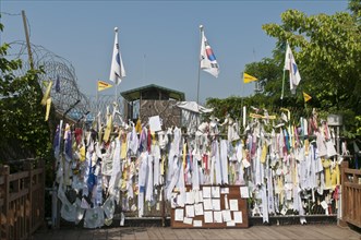 Messages and flags pinned to the barricade at the end of the Freedom Bridge within the Demilitarized Zone