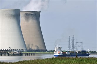 Container ship on the river Scheldt in front of the cooling towers of the nuclear power plant at Doel