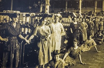 Old archival photograph showing female workers posing in spinning mill in the early twentieth century