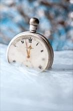 Old pocket watch frozen in some ice