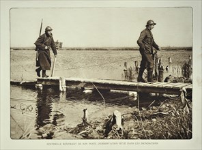 Soldier returning from observation post in flooded terrain in Flanders during the First World War