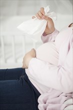 Pregnant woman holding vomit bag | MR:yes NH_pregnant_belly_mr