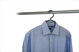 Business shirt hanging on a clothing rail and cut out on a white background