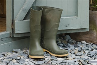 Pair of green wellington boots outside a garden shed