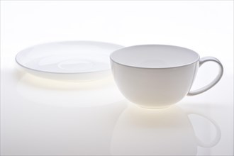 Cup and saucer standing separately on white background