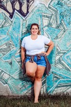 Plus Size Model with casual summer outfit on a graffiti wall