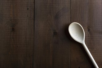 Traditional wooden spoon on a dark board background