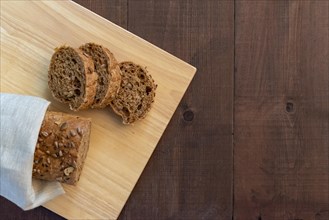 Sliced multi seeded baguette on a bread board