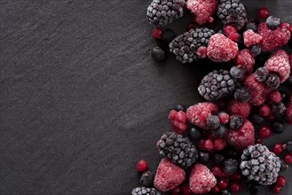 Frozen summer berries on a slate background