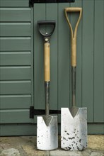 Border spade and digging spade against a shed