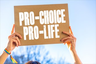 A woman holding a poster in her hands in favor of the legalization of abortion