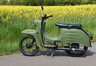 Moped Schwalbe from the GDR in front of a rape field