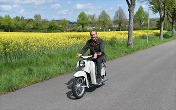 Man riding a moped Schwalbe from the GDR