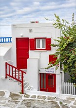 Cycladic white house with red shutters
