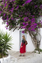 Young woman with red skirt in the alleys of the old town Chora