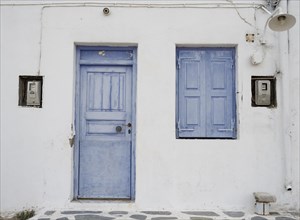 House facade with blue entrance door and shutters