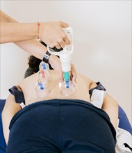 Physiotherapist placing cupping on patient