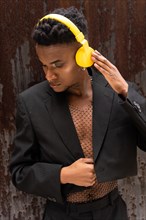 A man of black ethnicity listening to music wireless yellow headphones