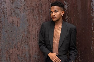 A black ethnic man in a fashion pose on a brown metallic background