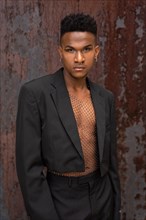 Black ethnic man in a fashionable pose on a metallic background