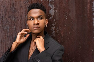 A male model of black ethnicity in a fashion pose on a brown metallic background