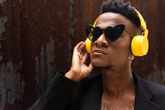 A black ethnic man listening to music wireless yellow headphones